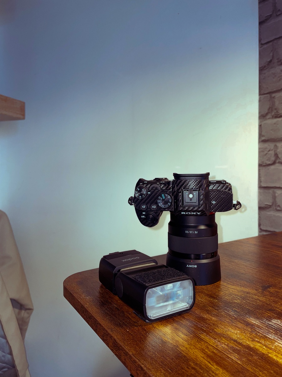 Boîtier Sony et flash Godox sur une table en bois