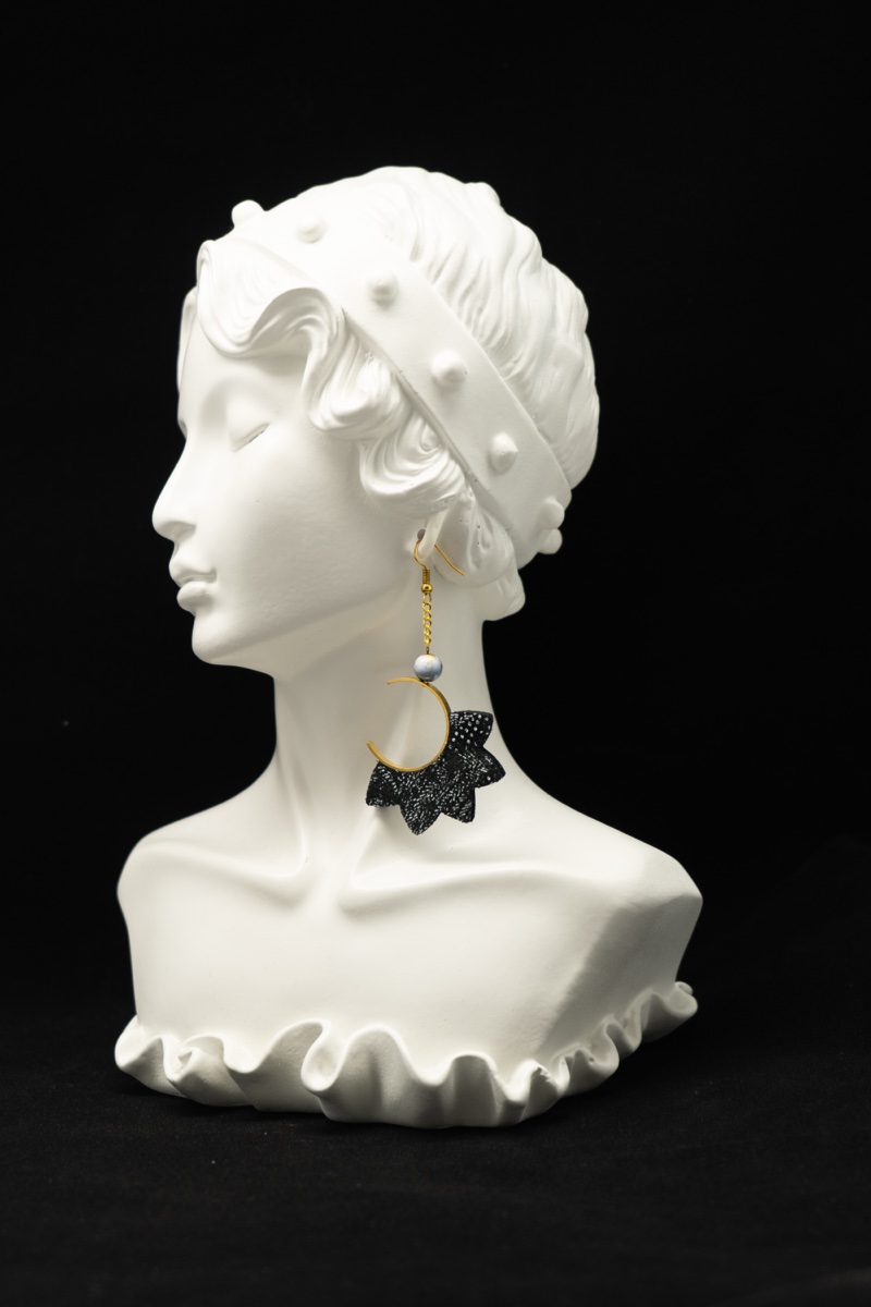 Boucle d'oreille noire dentelle sur buste, fond noir