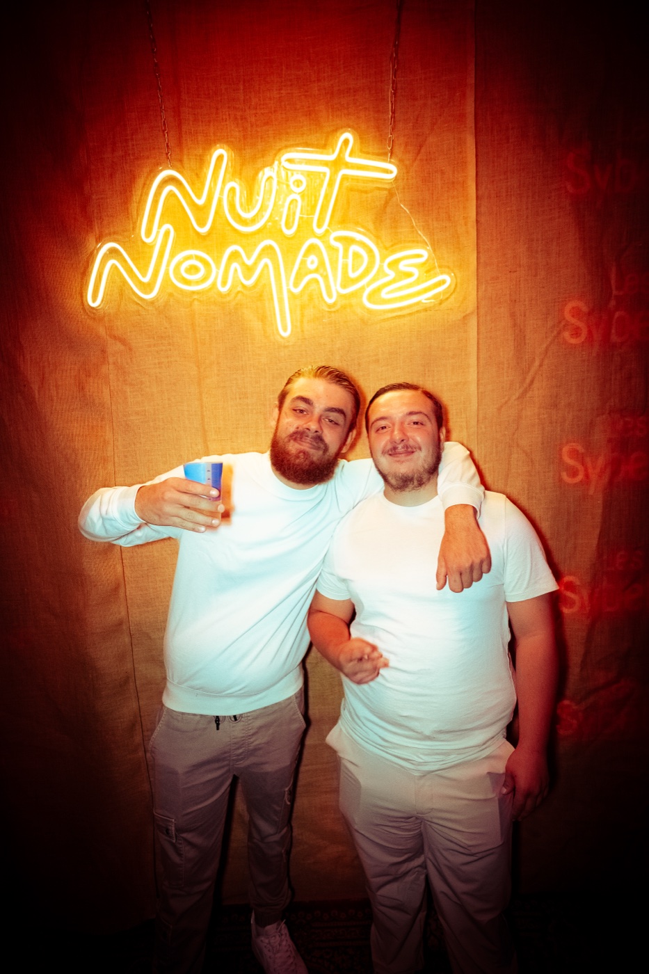 Invités devant le néon Nuit Nomade
